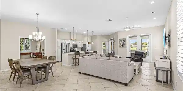 Image 4: Open-concept living area with tile flooring, recessed lighting, and a ceiling fan