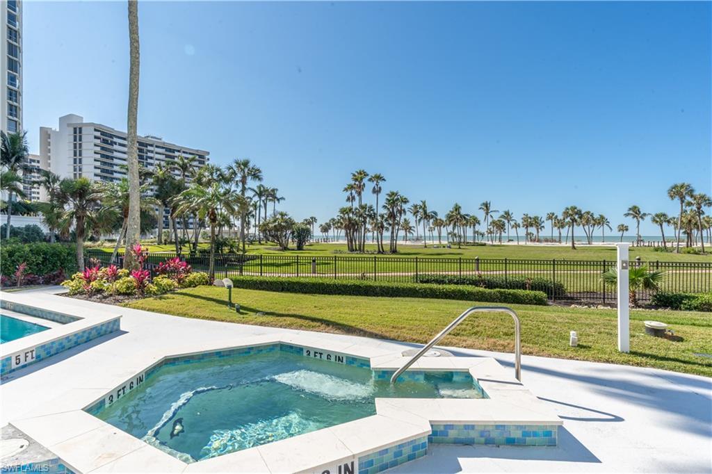 Image 3: View of pool with a hot tub and a yard