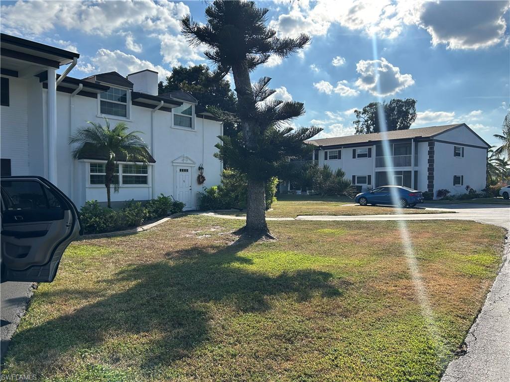 Image 3: View of front of property featuring a front yard and stucco siding