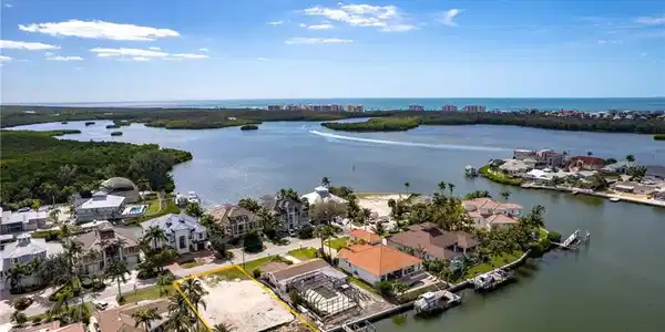 Image 3: Aerial view of residential area featuring a nearby body of water