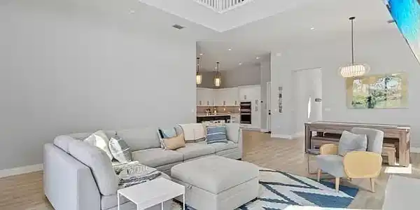 Image 3: Two-story living area with high ceilings and wood-finish flooring