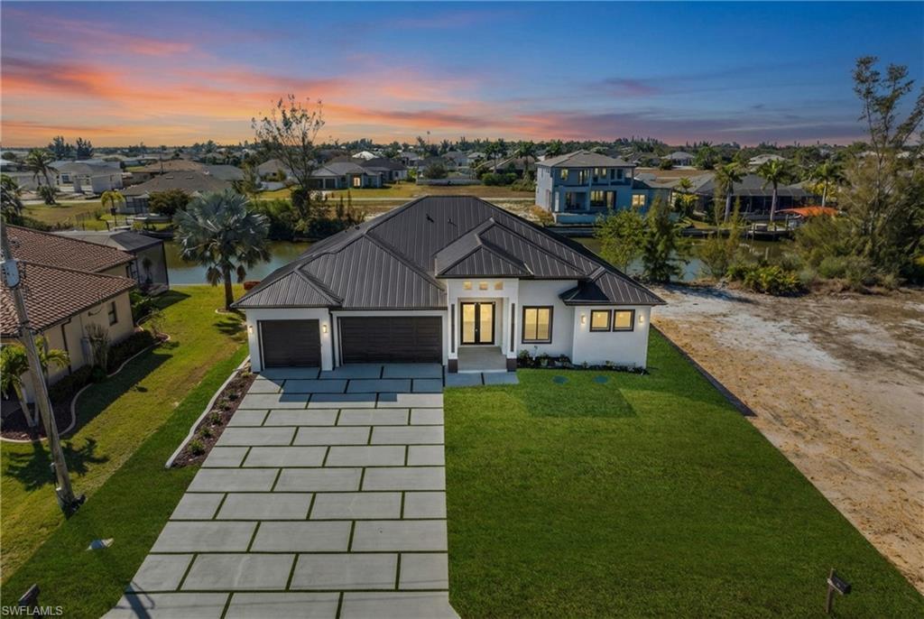 Image 1: Modern farmhouse featuring a garage, a front yard, driveway, and a metal roof