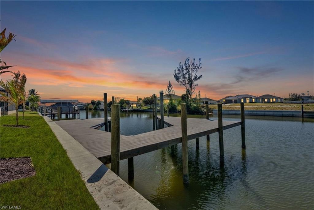Image 2: Dock area featuring a water view and a lawn