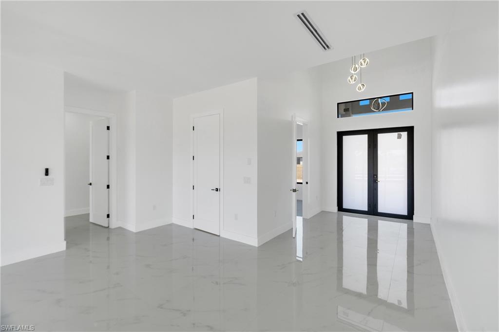 Image 4: Entryway with french doors and light marble finish floors