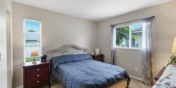 Image 3: Comfortable guest bedroom with abundant natural light, neutral finishes, and generous closet space.
