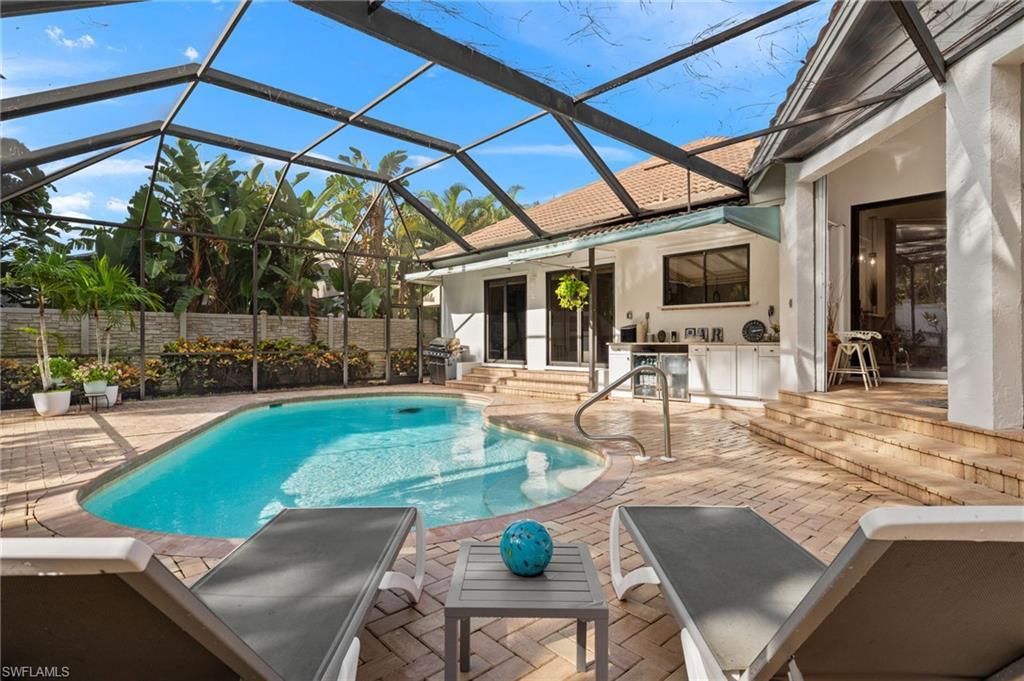 Image 2: View of pool featuring a lanai and a patio