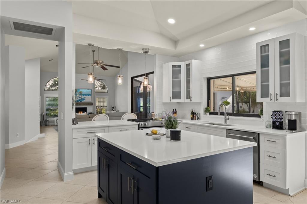 Image 3: Kitchen with lofted ceiling, a healthy amount of sunlight, a center island, and sink