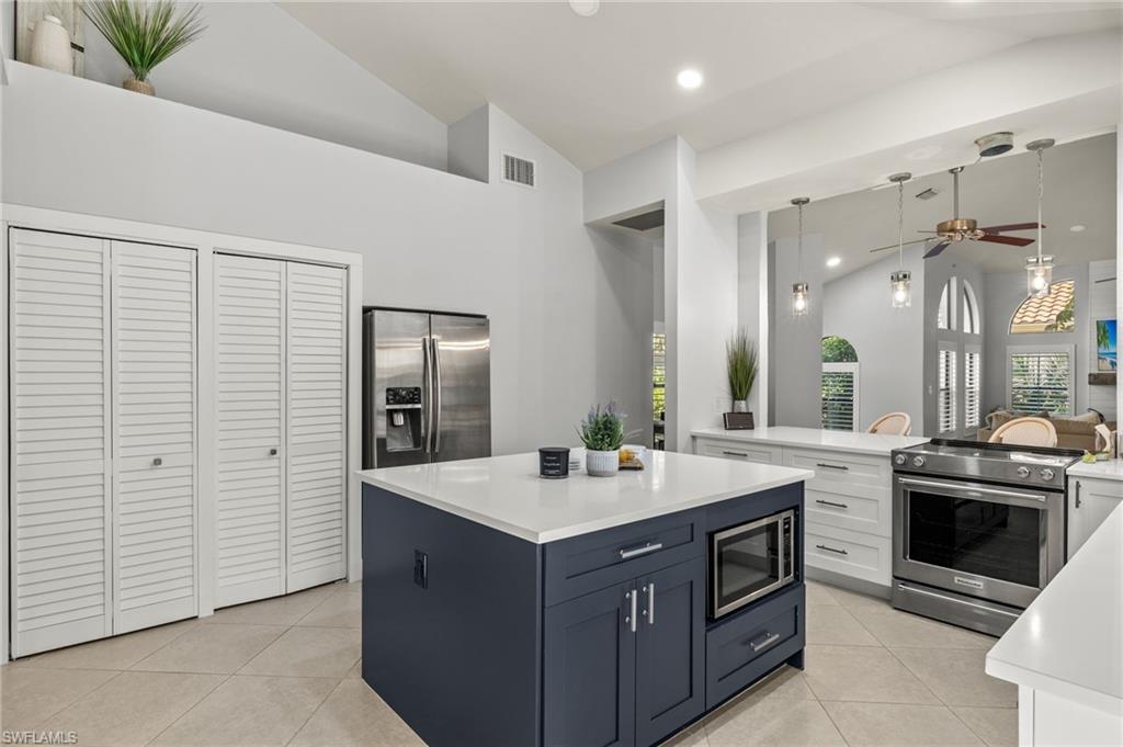 Image 4: Kitchen featuring ceiling fan, appliances with stainless steel finishes, white cabinets, and light tile patterned flooring