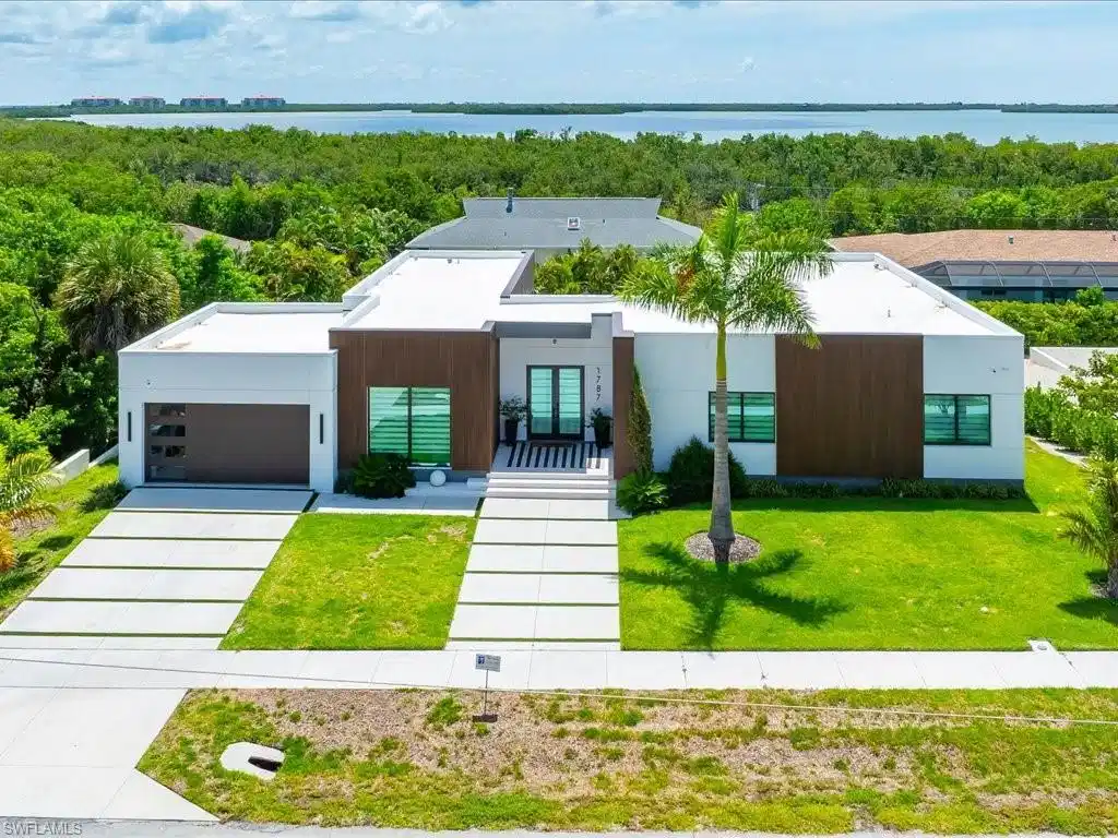 Image 1: Modern architectural exterior featuring white stucco and wood-finish paneling