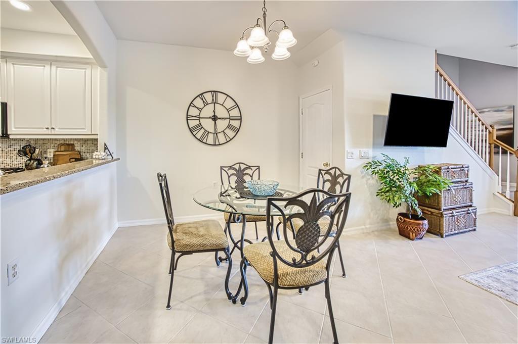 Image 4: Open-concept dining area featuring tiled flooring and a suspended light fixture