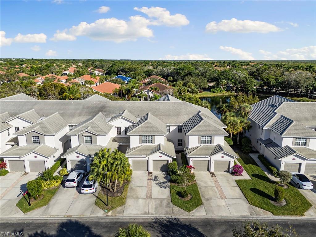 Image 3: Aerial perspective of suburban area with a nearby body of water and a tree filled landscape