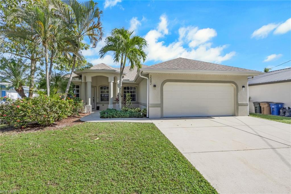Image 2: View of front of home with stucco siding, concrete driveway, an attached garage, and a front lawn