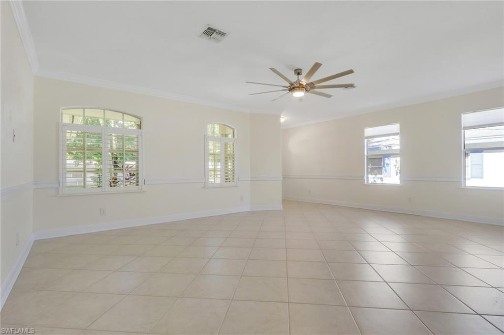 Image 4: Spare room with crown molding, ceiling fan, and light tile patterned floors