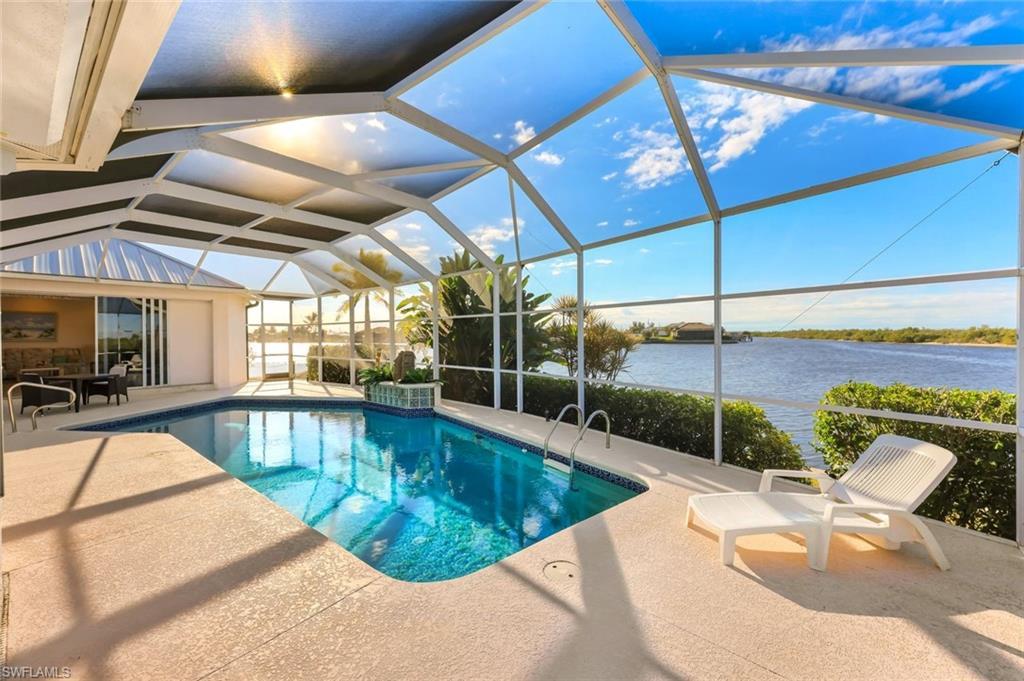 Image 2: Outdoor pool with a sunroom, glass enclosure, a patio, and a water view