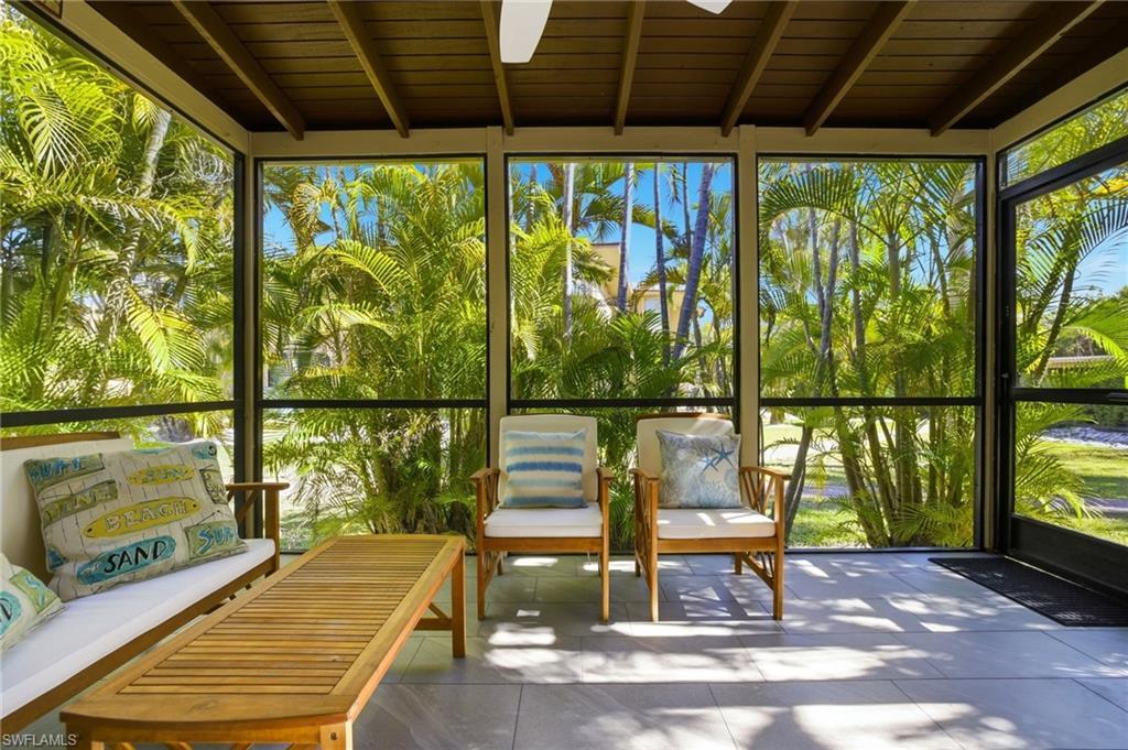 Image 3: Sunroom with floor to ceiling windows and a wood ceiling with exposed beams