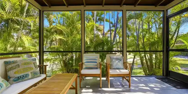 Image 3: Sunroom with floor to ceiling windows and a wood ceiling with exposed beams