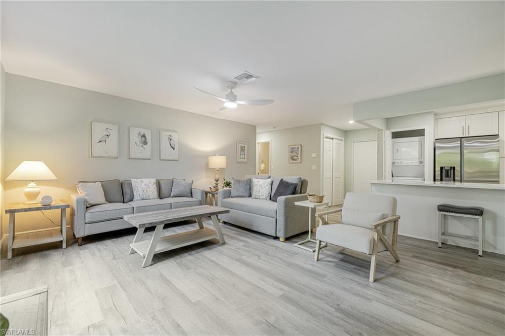 Image 4: Great room featuring light wood-style flooring, a ceiling fan, and stacked washer / drying machine