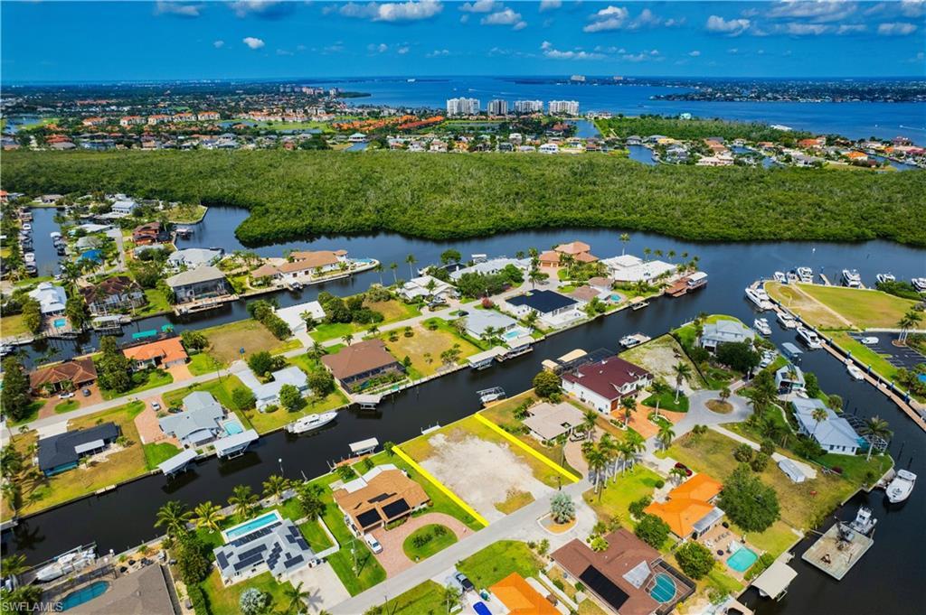Image 4: Aerial view of property's location featuring a large body of water, nearby suburban area, and property parcel outlined