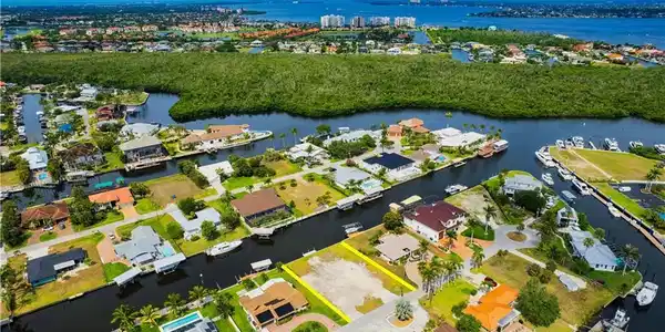Image 4: Aerial view of property's location featuring a large body of water, nearby suburban area, and property parcel outlined