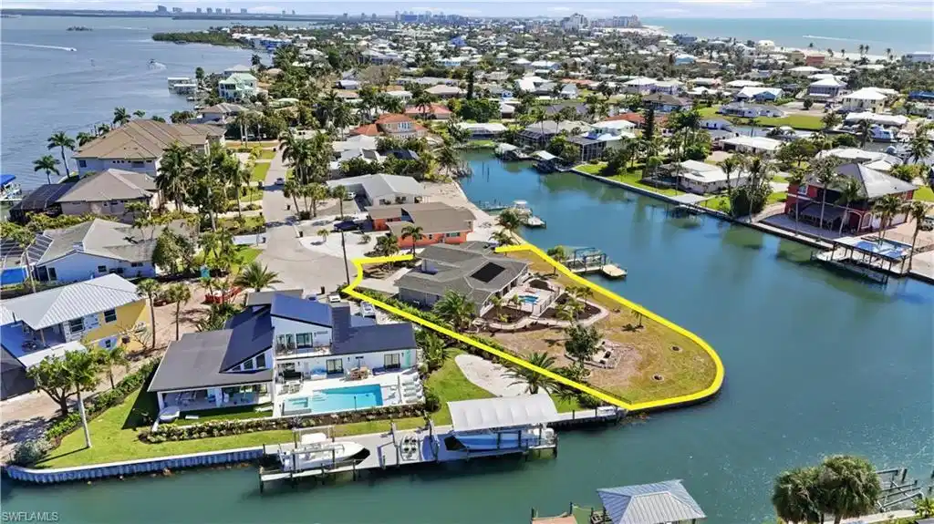 Image 1: Aerial view of residential area featuring a nearby body of water - Virtually Edited Image