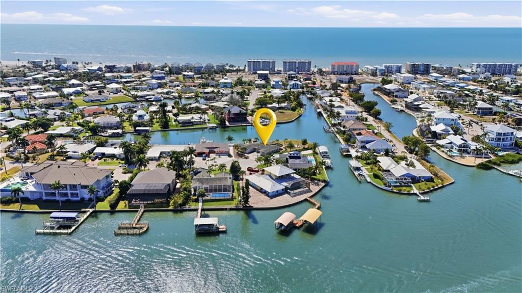 Image 2: Aerial view of property and surrounding area with a large body of water and nearby suburban area - Virtually Edited Image