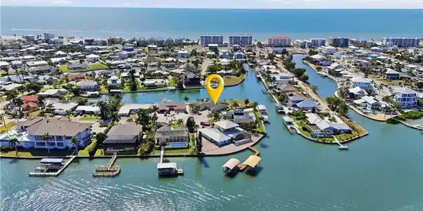 Image 2: Aerial view of property and surrounding area with a large body of water and nearby suburban area - Virtually Edited Image