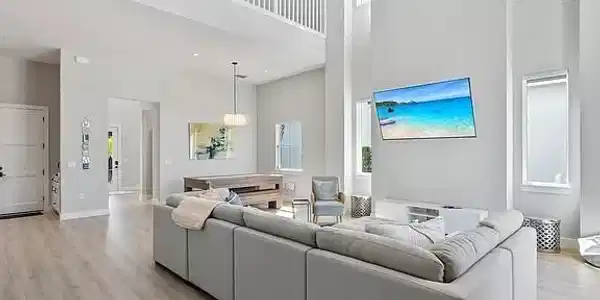 Image 2: Expansive living area featuring soaring ceilings and light wood-finish flooring
