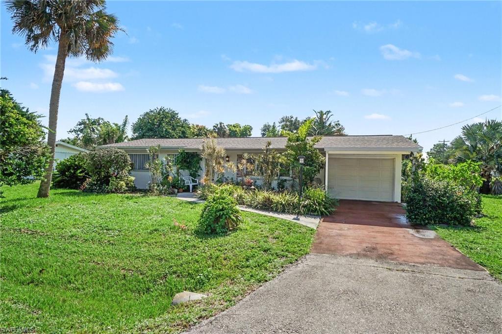 Image 2: Ranch-style exterior with an attached garage, featuring a paved driveway and a front walkway