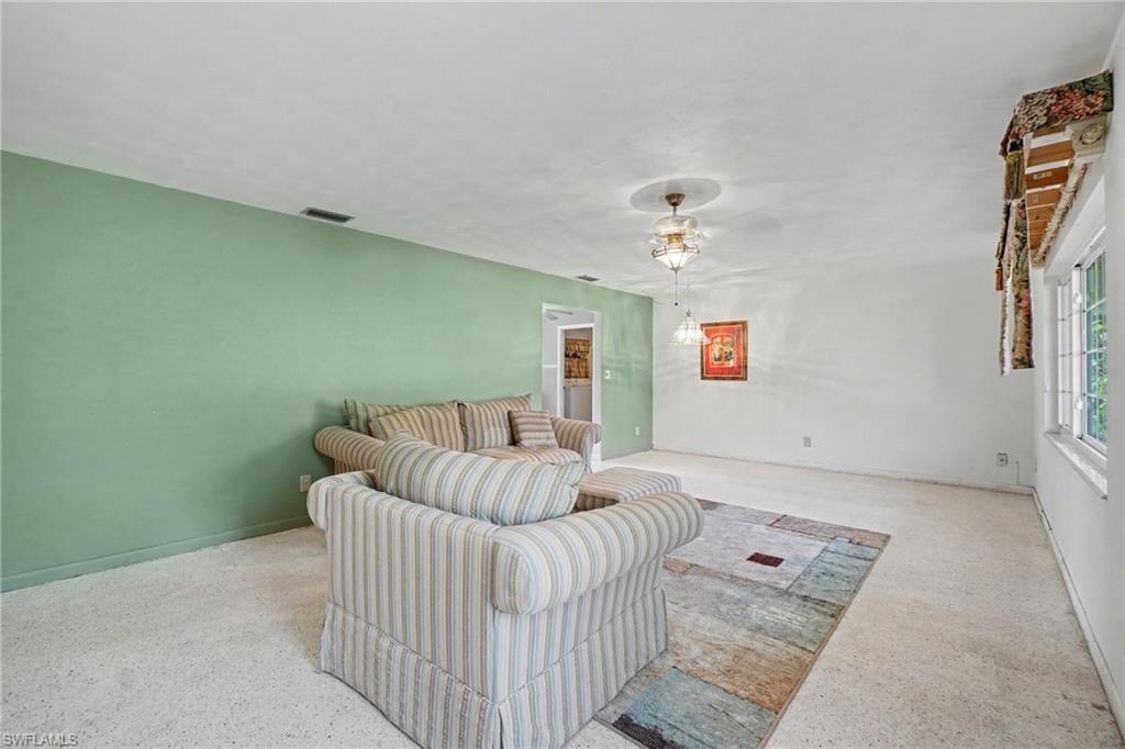 Image 4: Spacious interior featuring a recessed ceiling light fixture, a wide window, and a light-colored carpeted floor