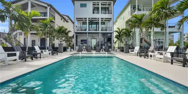 Image 3: Swimming pool with stairs, a patio area, and a balcony - Virtually Edited Image