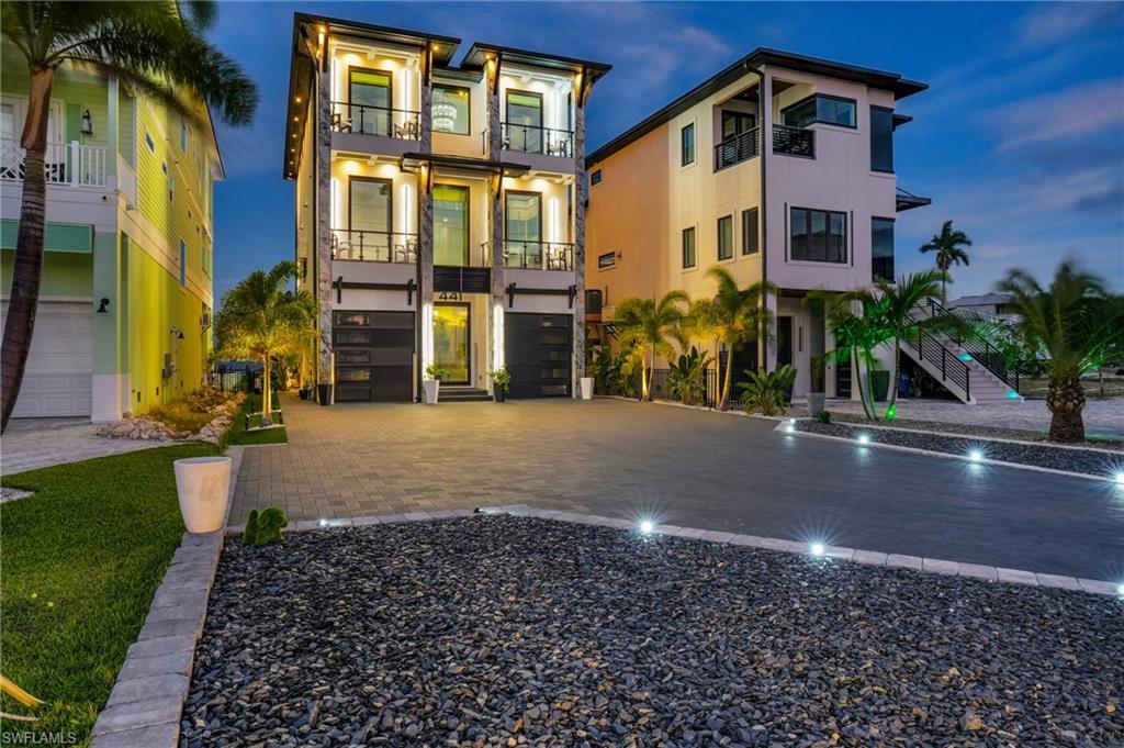 Image 4: View of front of house featuring stucco siding, decorative driveway, stairs, and an attached garage