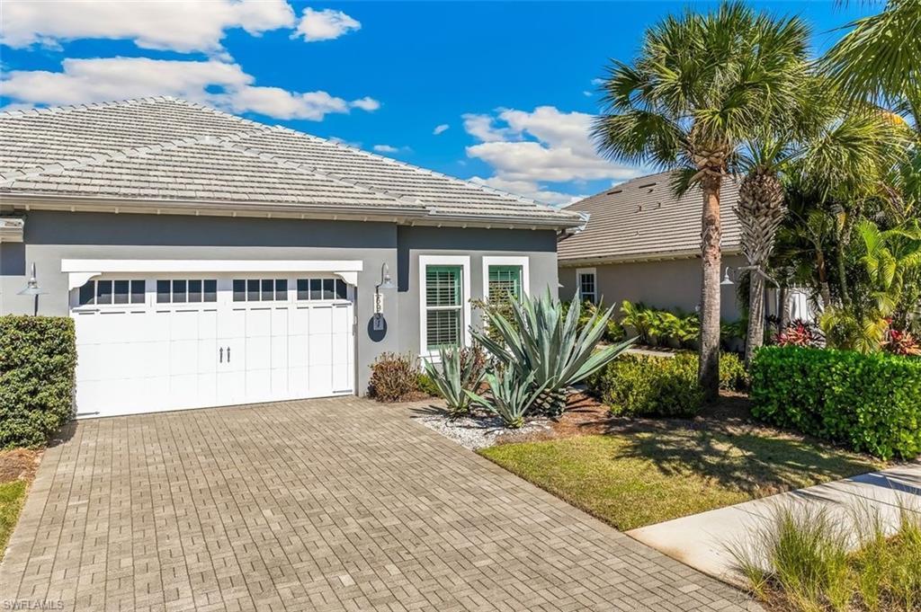 Image 4: View of front of property with stucco siding, a tiled roof, decorative driveway, and a garage
