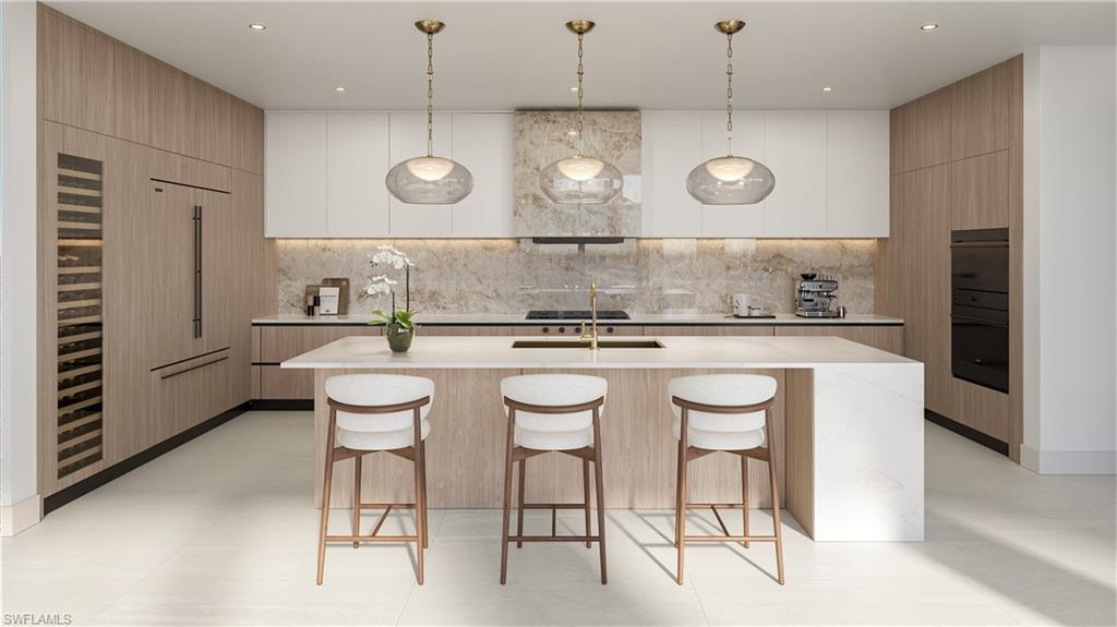 Image 4: Kitchen with two tone cabinets, modern cabinets, a kitchen bar, a kitchen island with sink, and decorative light fixtures