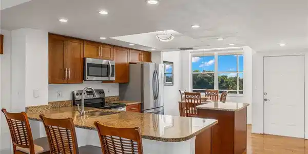 Image 4: Kitchen featuring granite countertops, wood cabinetry, and stainless steel appliances