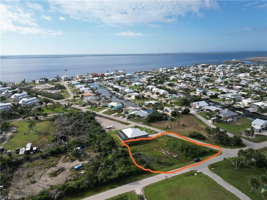 Image 1: Aerial view of residential area with a nearby body of water