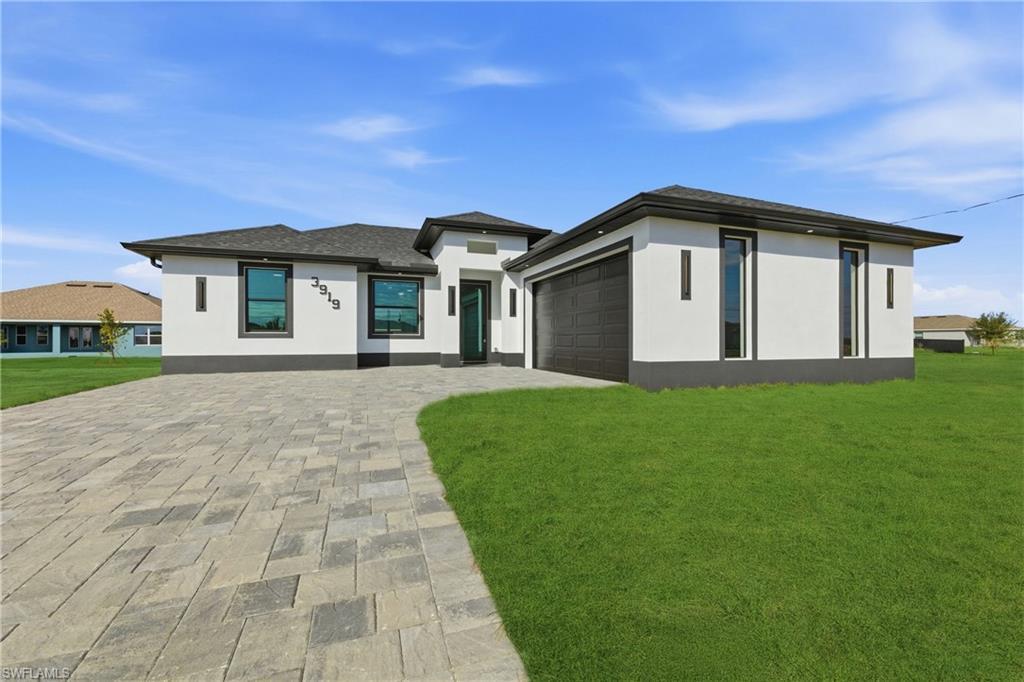 Image 2: Prairie-style home with stucco siding, a front yard, driveway, and an attached garage