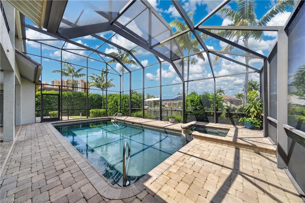 Image 2: The property features a screened-in pool area with a swimming pool and an integrated spa