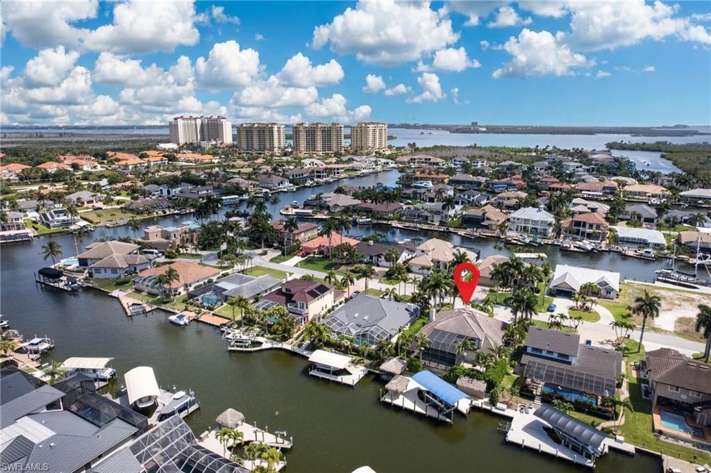 Image 4: This property offers a waterfront location with a private boat lift and dock, surrounded by lush tropical landscaping