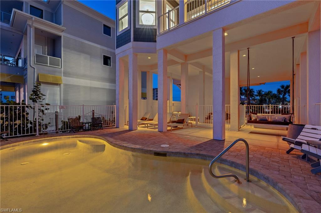Image 3: Pool at dusk featuring an outdoor pool, a patio area, and a balcony