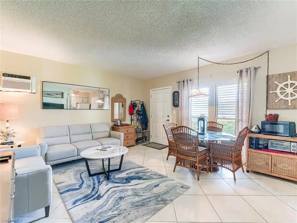Image 1: Living area featuring a textured ceiling and light tile patterned floors