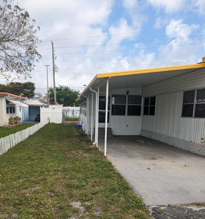 Image 3: View of home's exterior with an attached carport and concrete driveway