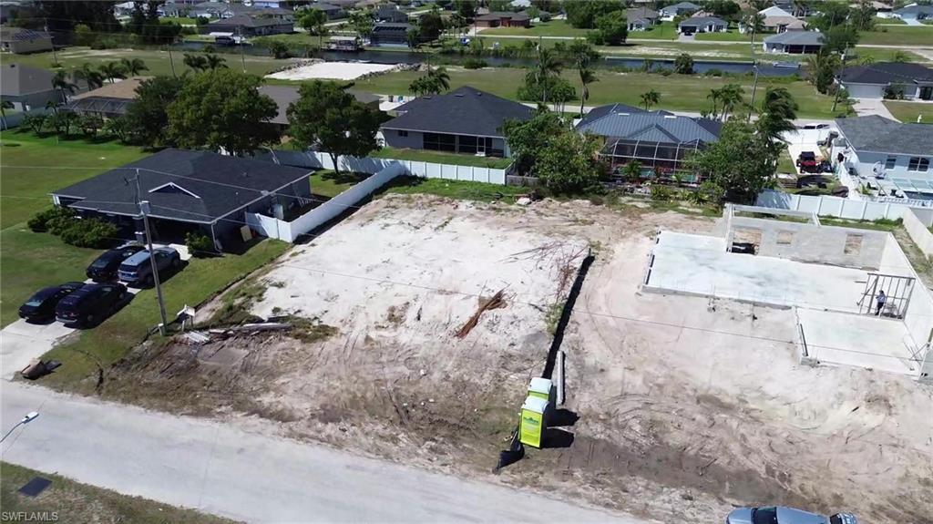 Image 3: Aerial view of residential area featuring a nearby body of water