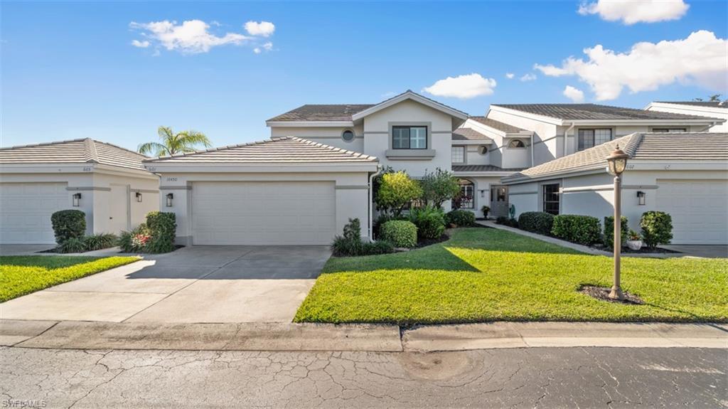 Image 1: Traditional home featuring a front lawn, stucco siding, concrete driveway, an attached garage, and a tile roof