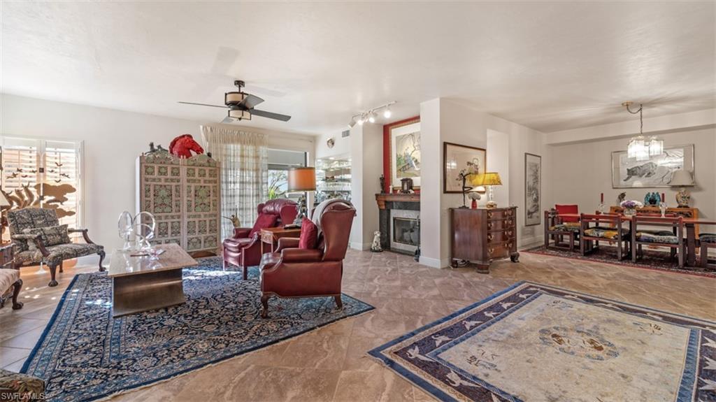 Image 4: Living room featuring a fireplace, a chandelier, ceiling fan, and rail lighting