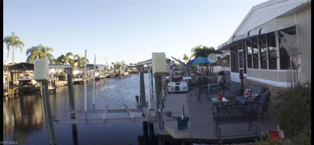 Image 3: Dock featuring a water view and boat lift