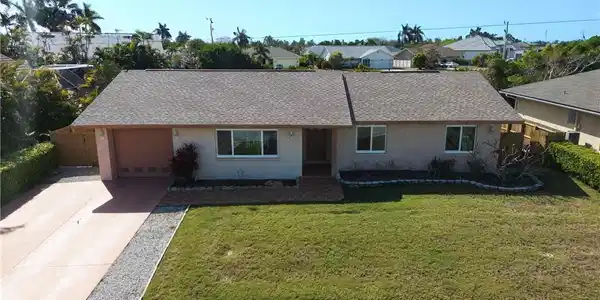 Image 4: Ranch-style home featuring concrete driveway, stucco siding, a shingled roof, and an attached garage