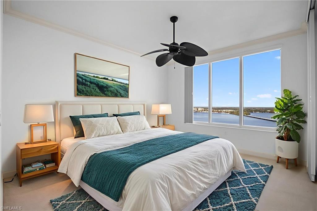 Image 2: Carpeted bedroom with a water view, ornamental molding, and ceiling fan