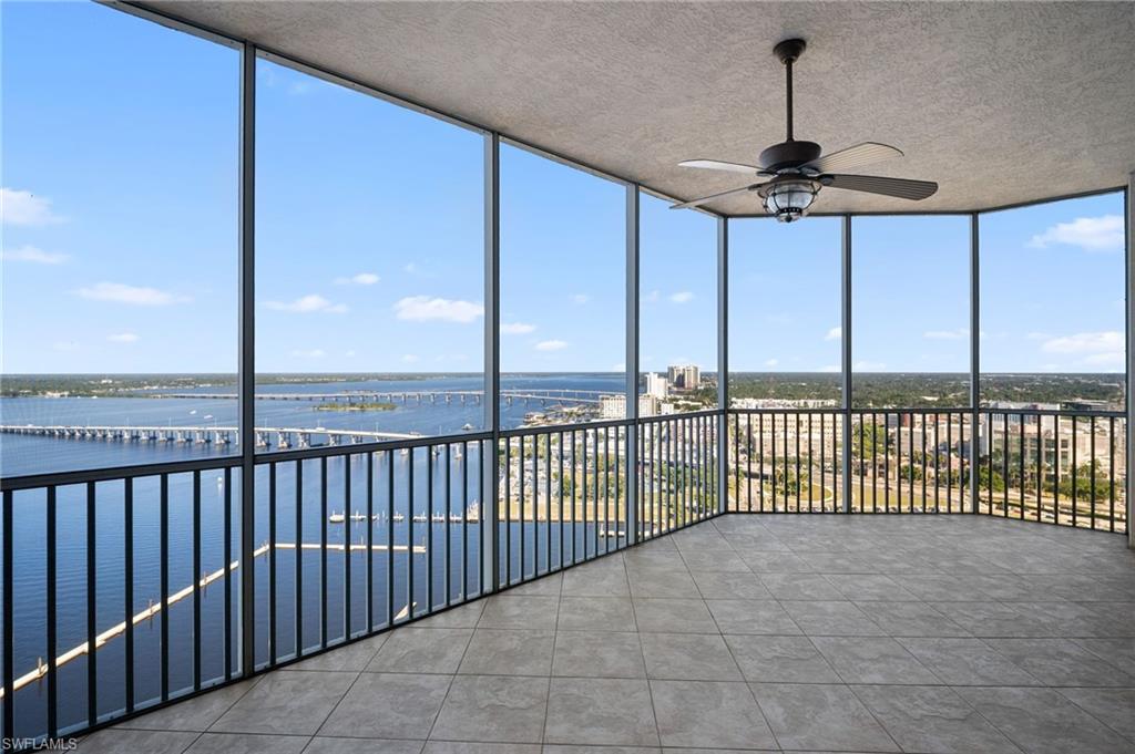 Image 3: Unfurnished sunroom featuring floor to ceiling windows, a water view, tile patterned flooring, and a textured ceiling