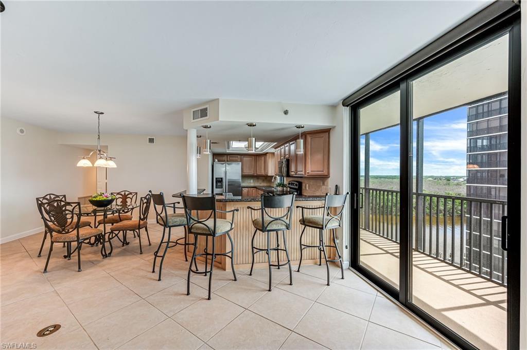 Image 4: Kitchen featuring light tile patterned floors, stainless steel fridge with ice dispenser, and kitchen peninsula