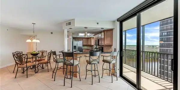 Image 4: Kitchen featuring light tile patterned floors, stainless steel fridge with ice dispenser, and kitchen peninsula